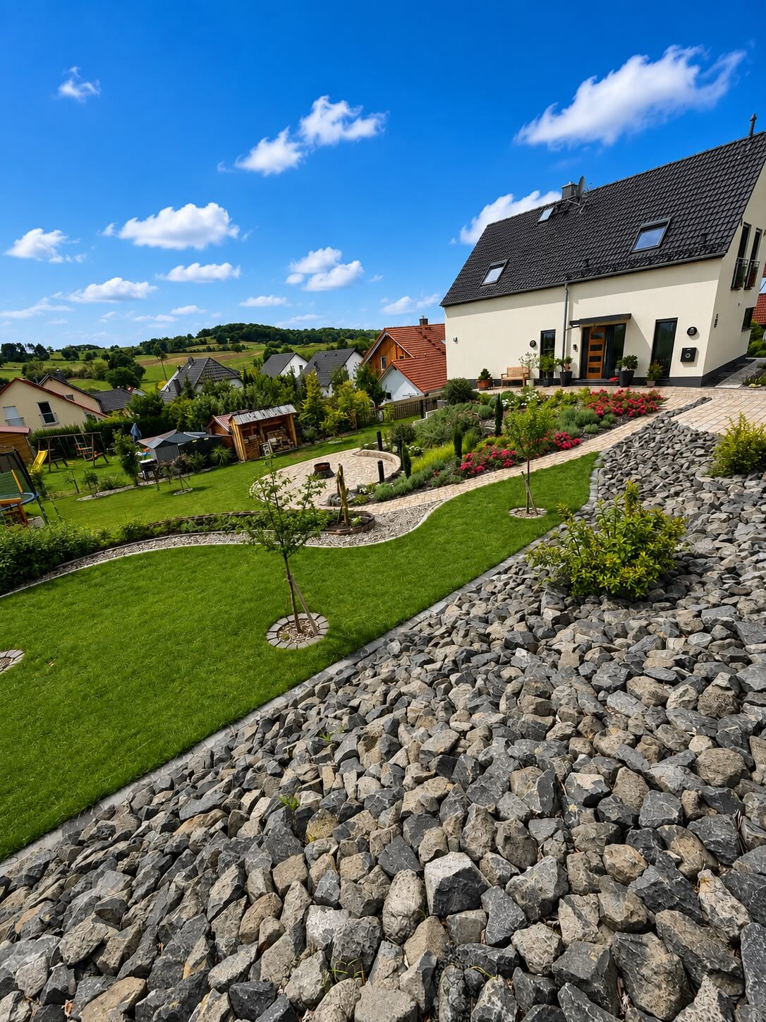 Gartenanlage in Hanglage mit geschwungenem Pflasterweg
