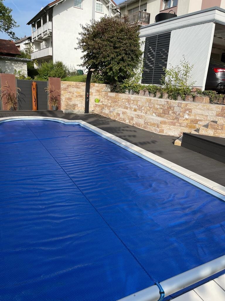 Pool mit Natursteinmauer und WPC-Terrasse